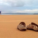 Unas chanclas sobre la arena mojada